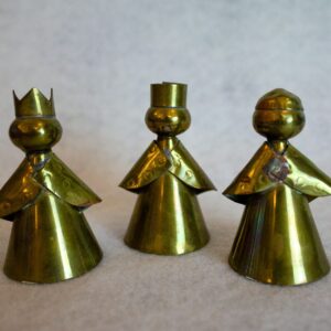 three gold colored metal figures on a white surface
