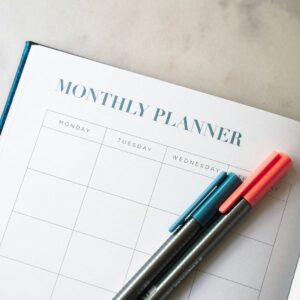 a planner with two pens sitting on top of it