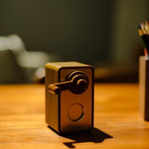 A vintage pencil sharpener on a wooden desk.