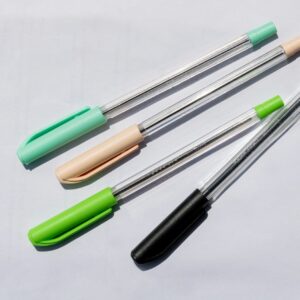 Four pens with colored caps on a white surface.